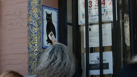 Una persona frota un décimo de Lotería de Navidad recién comprado en la Administración de Loterias del Gato Negro de Sevilla Una persona frota un décimo de Lotería de Navidad recién comprado en la Administración de Loterias del Gato Negro de Sevilla